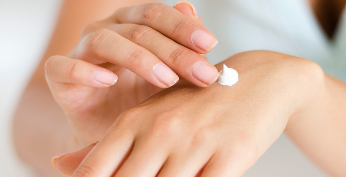 Woman applying skin cream to her hands